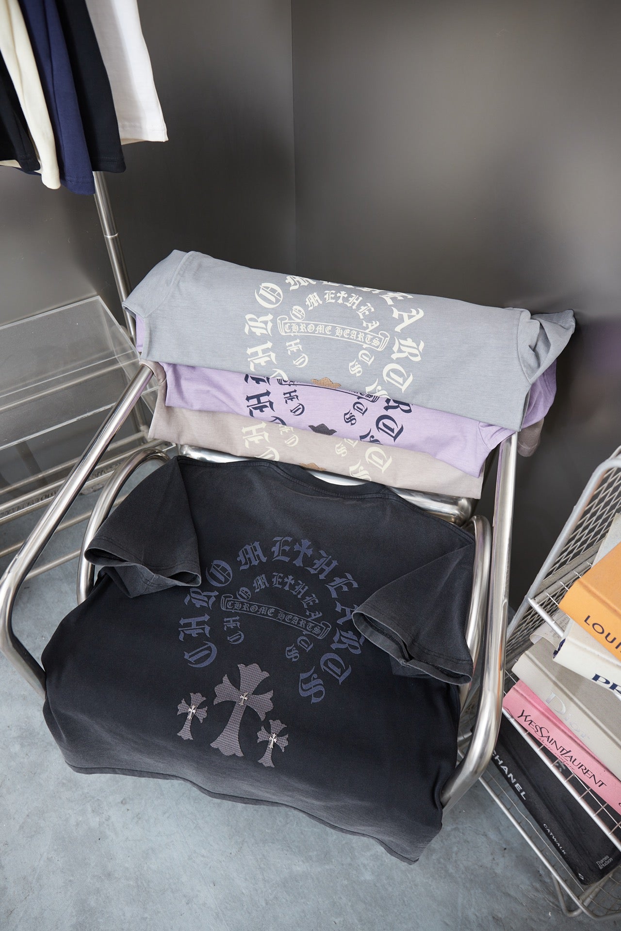 Folded T-shirts in black, gray, and light purple with matching graphics