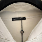 Close-up of white hoodie hood label with drawstring and cord end details