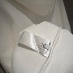 Close-up of white hoodie tag stitched near the zipper seam