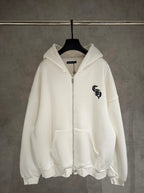 White zip-up hoodie with hood and front pocket; small black logo on chest