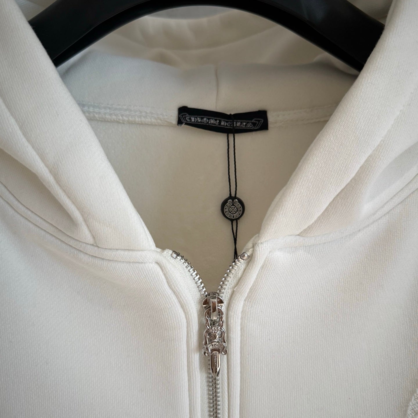 White zip-up hoodie hood with black inner label and silver-tone zipper pulls
