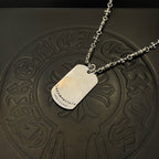 Single silver-tone chain necklace with rectangular pendant and star emblem on embossed mat