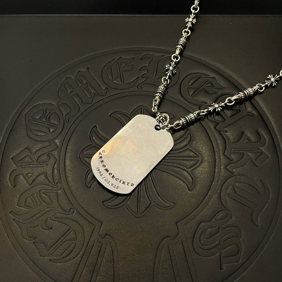 Single silver-tone chain necklace with rectangular pendant and star emblem on embossed mat