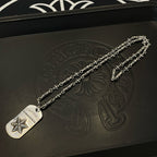 Necklace pendant and chain set on dark leather pouch with embossed pattern