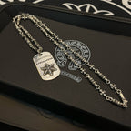 Double-chain necklace with two rectangular star pendants on dark jewelry box