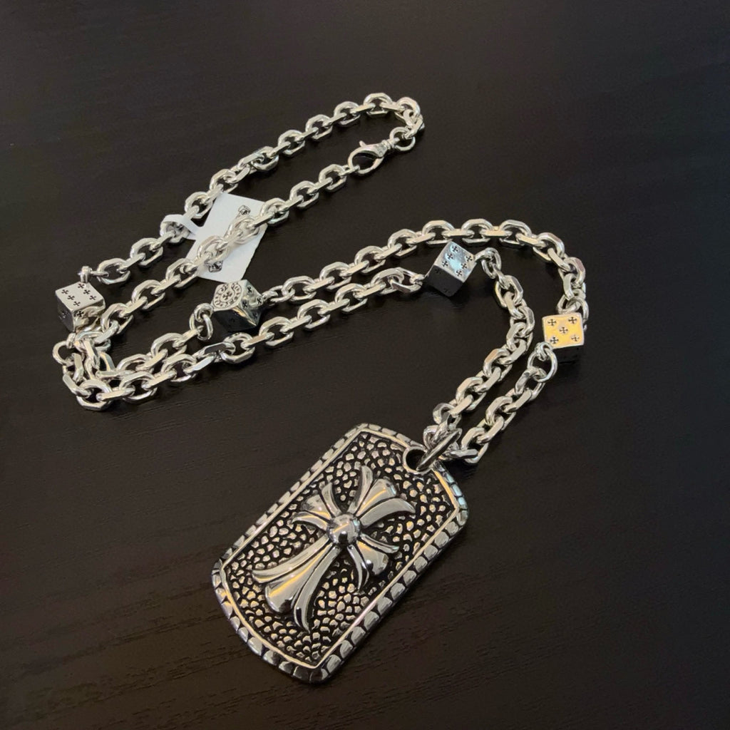 Silver-tone chain necklace with large rectangular cross pendant and charm details