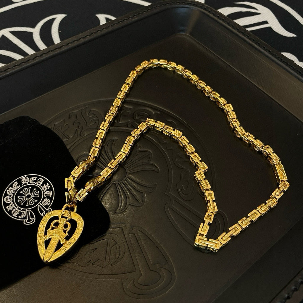 Gold-tone chain necklace with round teardrop pendant on black tray