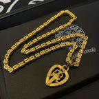 Gold-tone long necklace with teardrop pendant charm on black gift box
