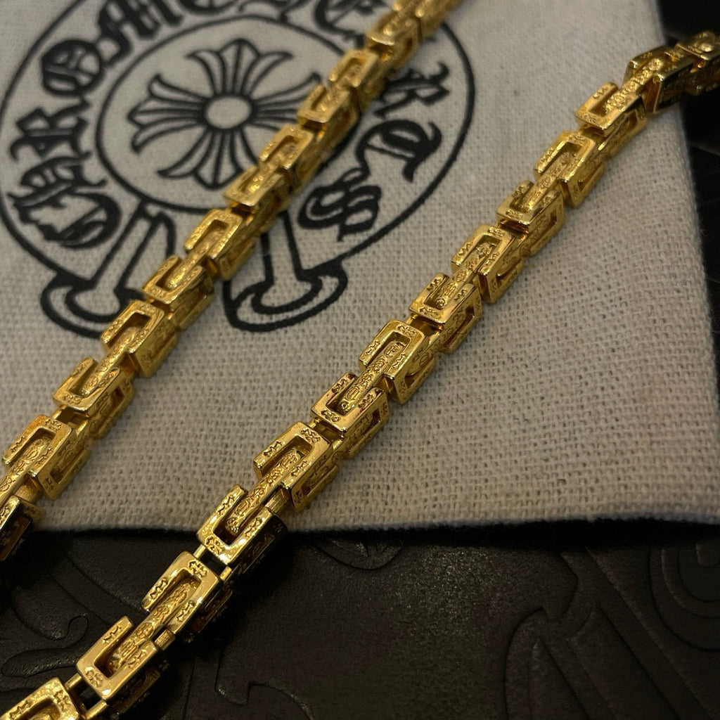 Gold-tone necklace chain links with engraved-style pattern detail
