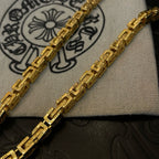 Gold-tone necklace chain links with engraved-style pattern detail