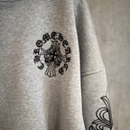 Light gray hoodie sleeve with black floral medallion print and arm swirl design