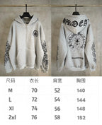 Light gray zip hoodie with black emblem on chest and ornate sleeve prints