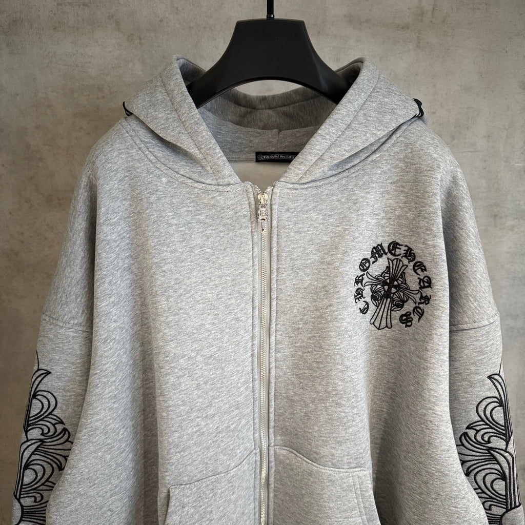 Light gray zip hoodie with black chest medallion and swirl sleeve motifs