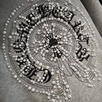 Light gray hoodie front jeweled circular emblem with pearl-like bead details