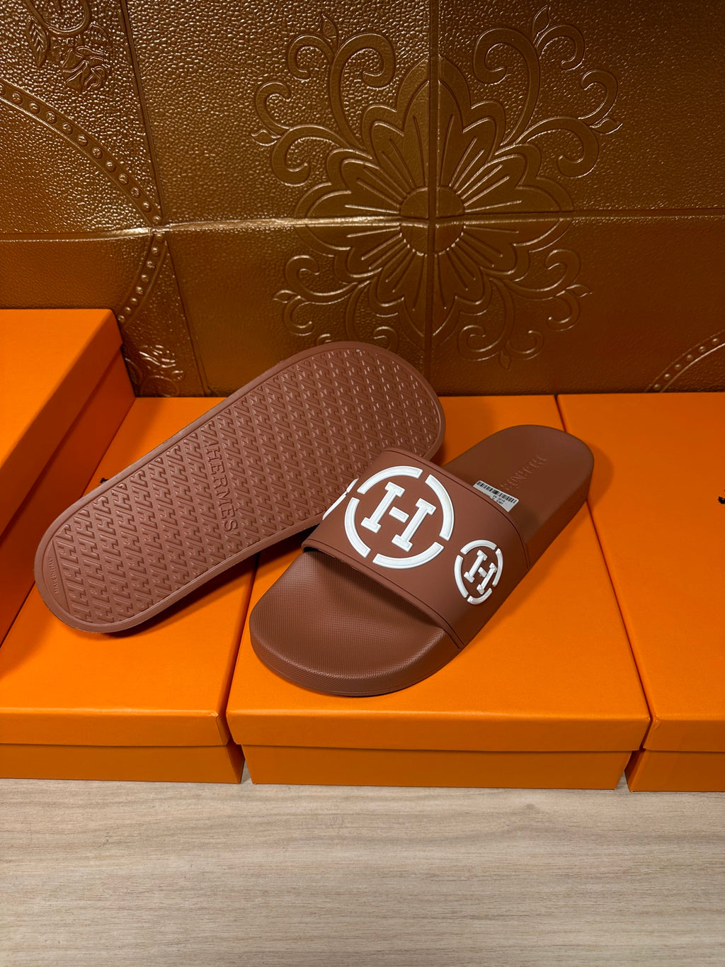 Brown slide sandals with white logo straps, sole and footbed visible