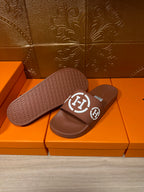 Brown slide sandals with white logo straps, sole and footbed visible