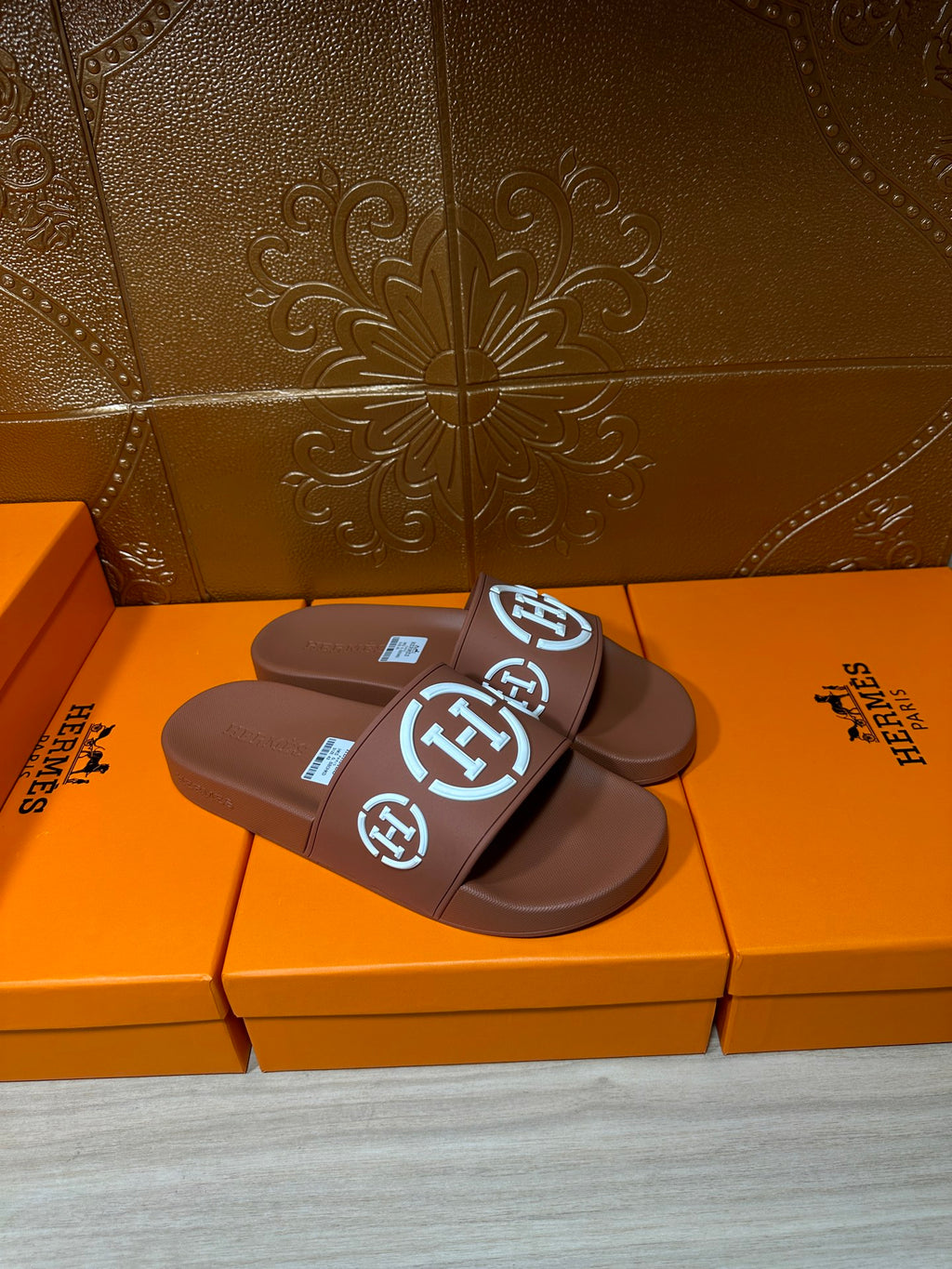 Dark blue slide sandals with white logo straps, stacked pair view