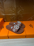 Dark blue slide sandals with white logo straps, stacked pair view