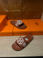 Brown slide sandals with white logo strap, one sandal and one slide view
