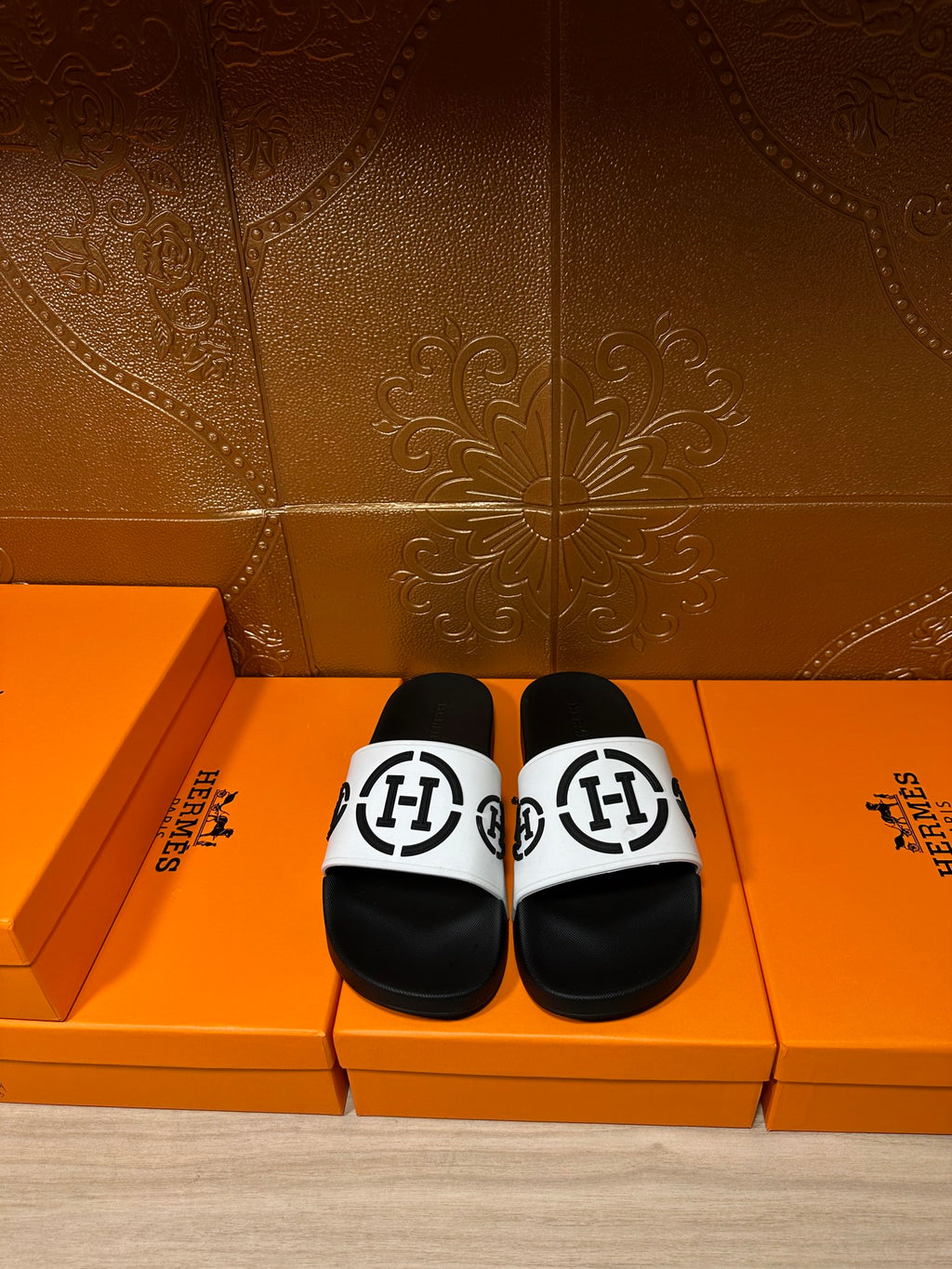 Black slide sandals with white logo strap, cushioned footbed