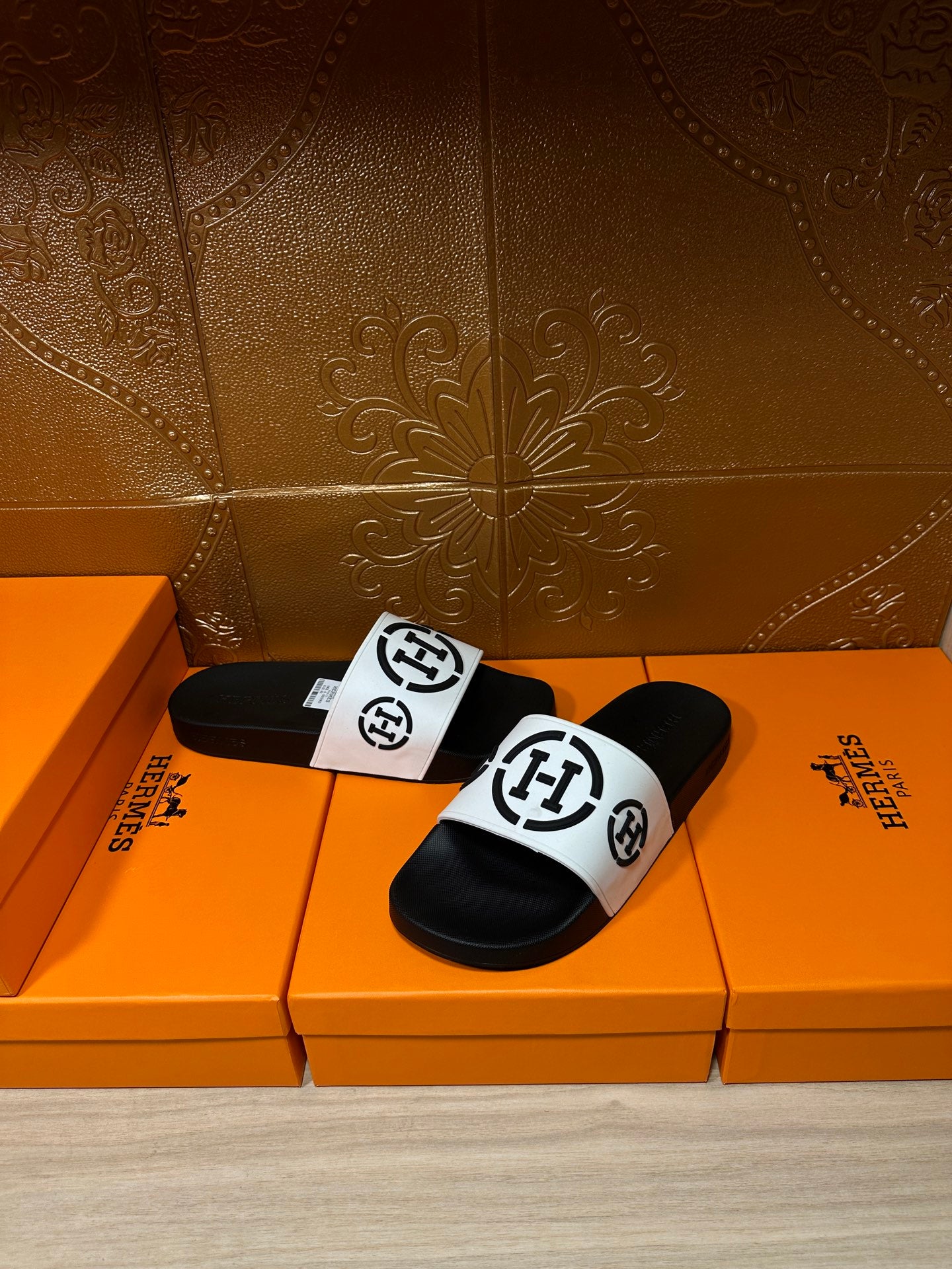 Black slide sandals with white logo strap, front view