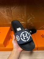 Handheld slide sandals: navy strap with white H logo over black footbed