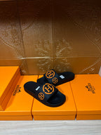 Hermes black slide sandals with two orange logo accents