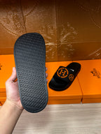 Hermes black slide sandals with textured footbed and patterned outsole