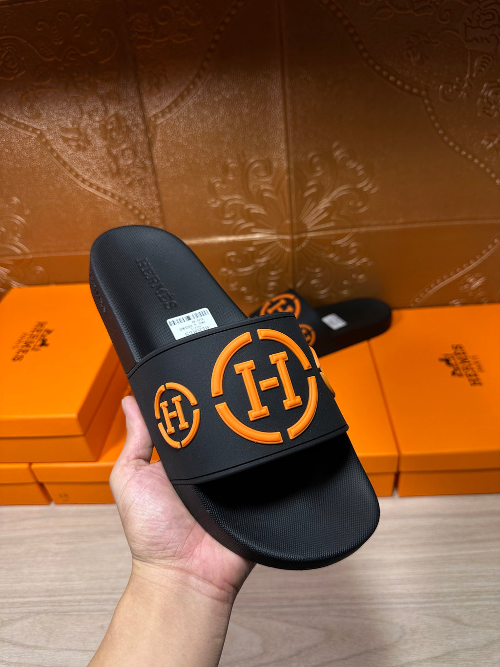 Hermes black slide sandal with orange logo strap and white size label