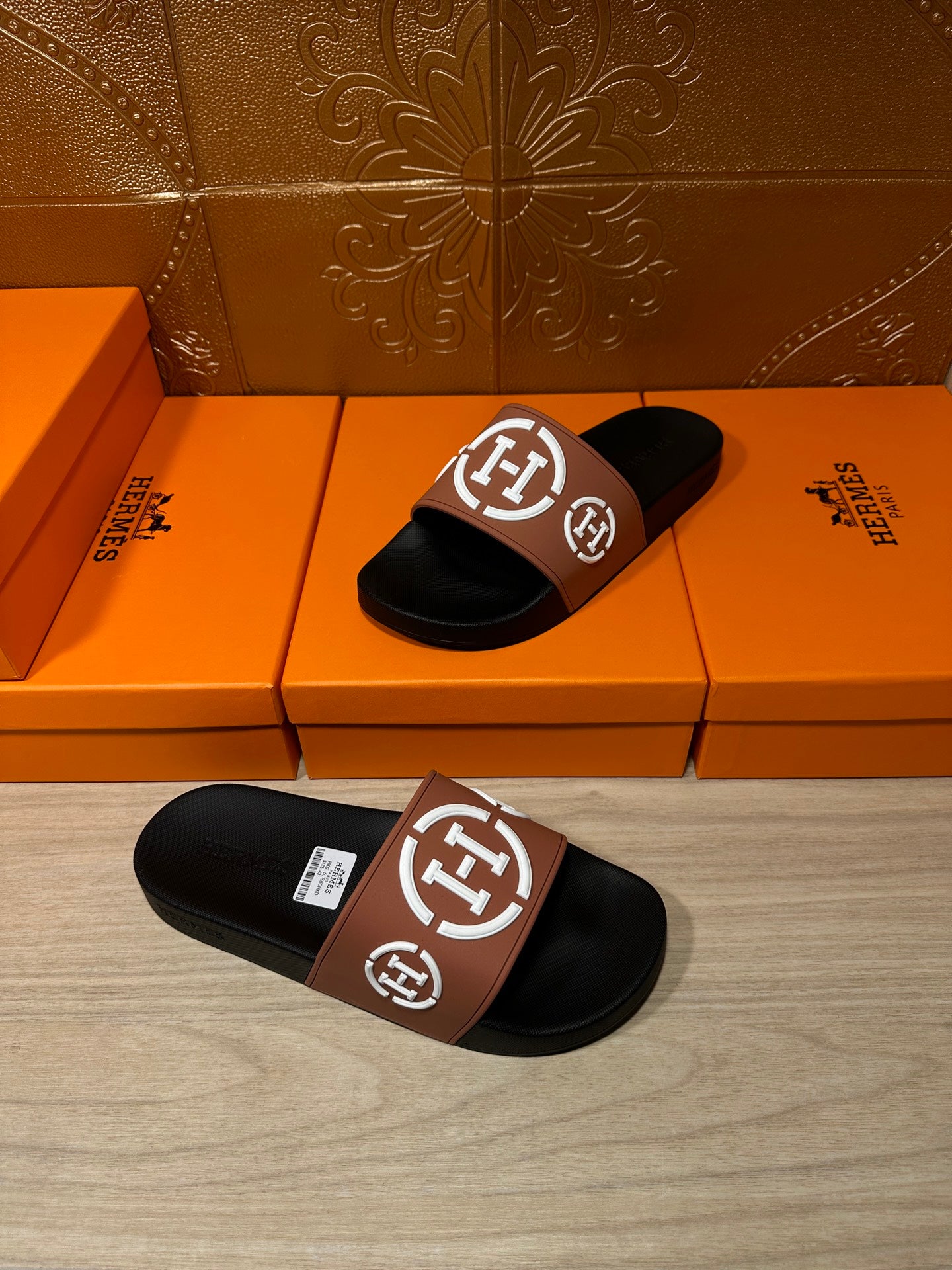 Hermes slide sandals with black footbeds and tan strap featuring white H logo