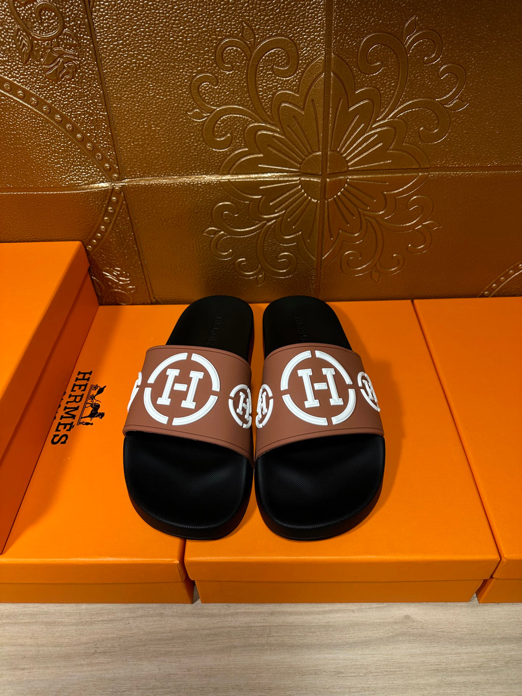 Hermes sandals with black slide footbed and tan strap featuring white H logo
