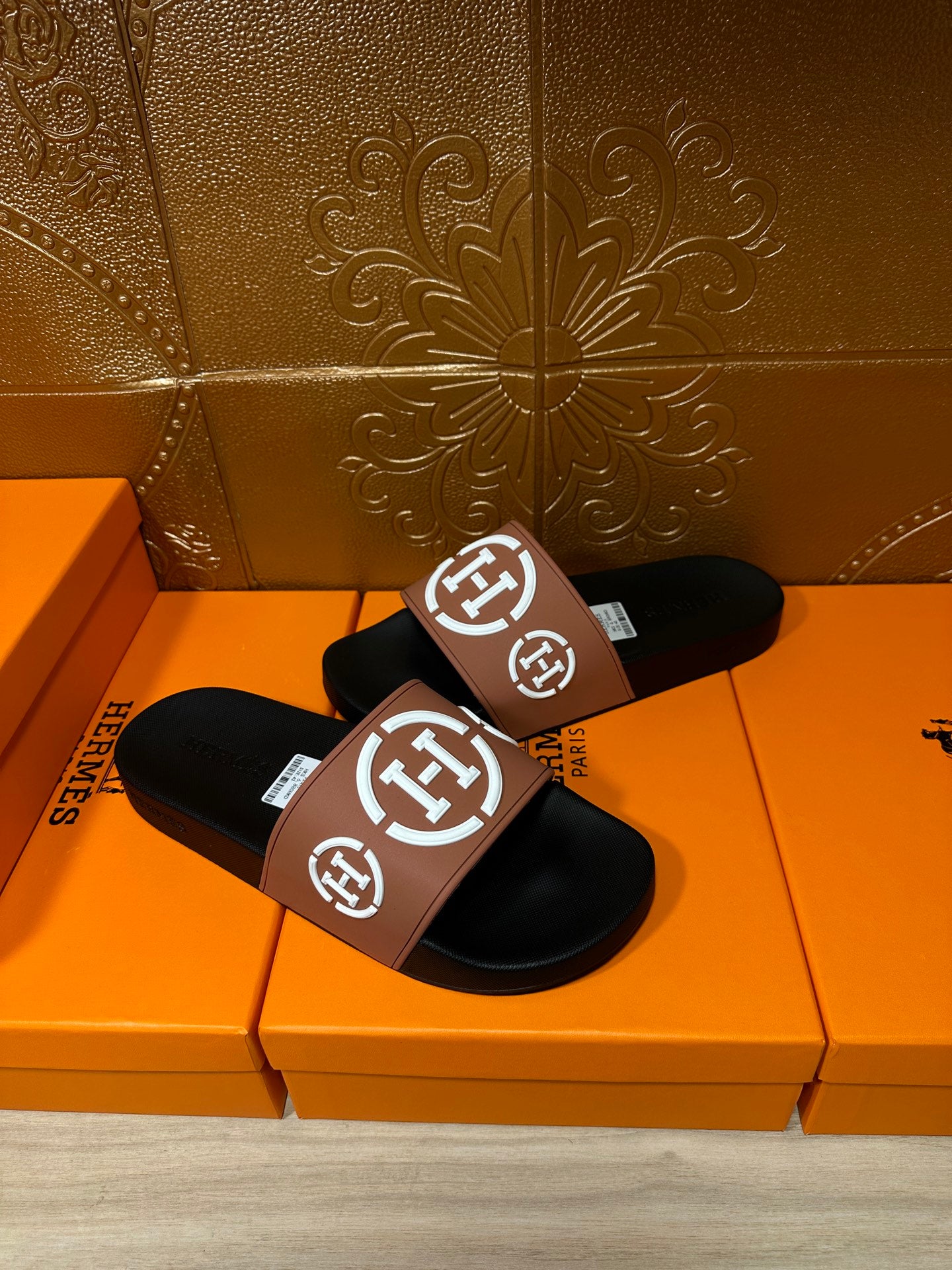 Hermes slide sandals with black footbeds and tan straps with white H emblem