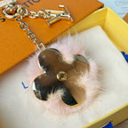 Louis Vuitton keychain detail: gold chain with heart mirror charm and pink fur