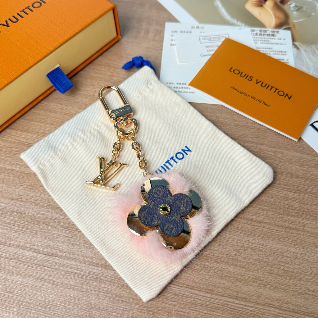 Louis Vuitton keychain with gold chain and blue floral charm on white pouch