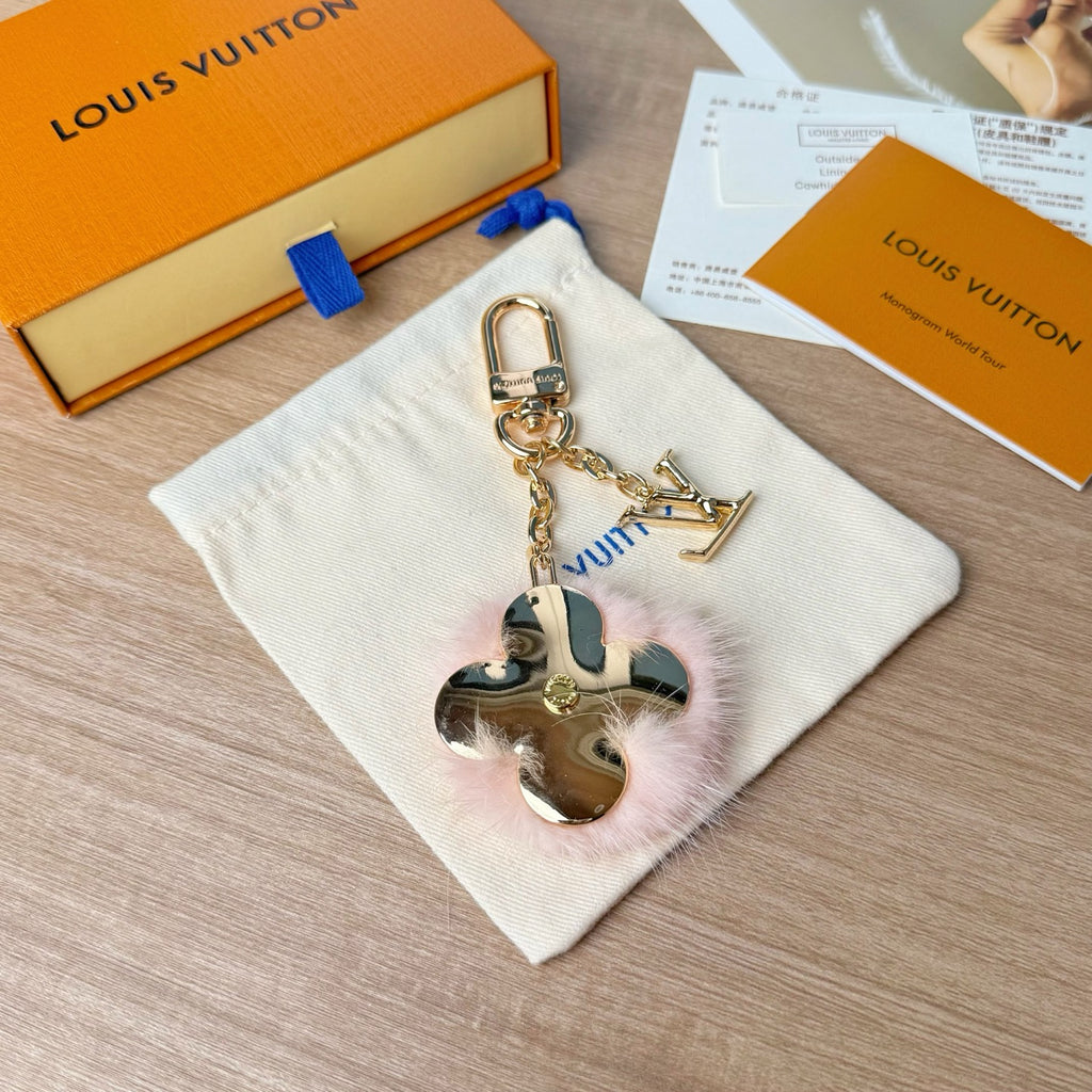 Louis Vuitton keychain with gold chain, blue floral charm, and heart mirror charm