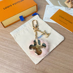Louis Vuitton keychain with gold chain, blue floral charm, and heart mirror charm