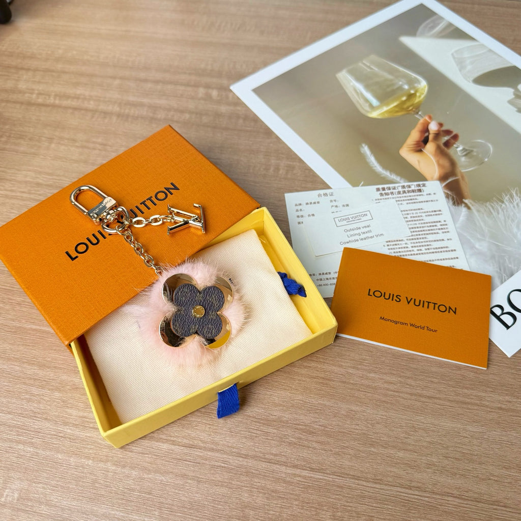 Louis Vuitton keychain in box with gold chain and blue flower charm with pink fur