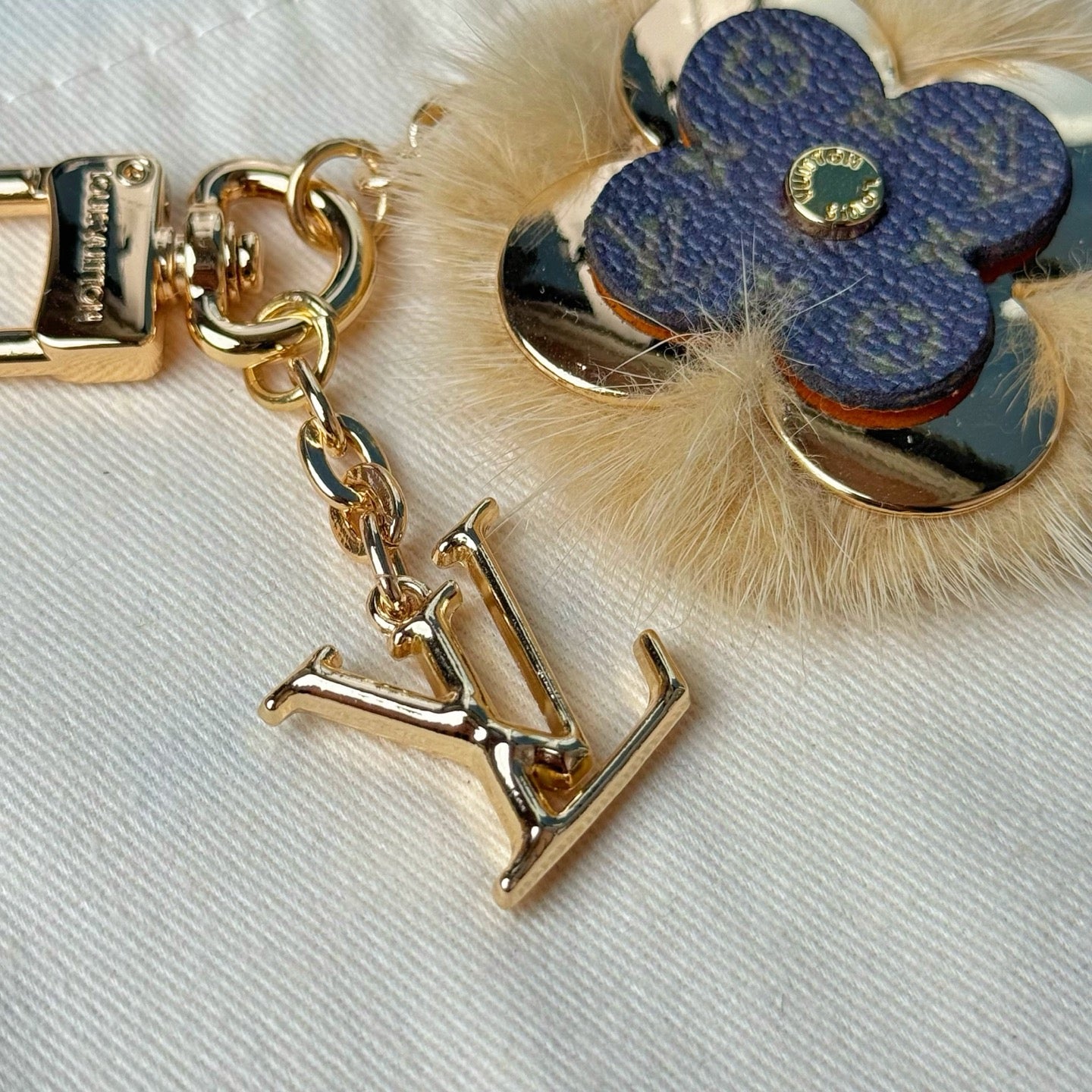 Louis Vuitton metal charm keychain clasp with blue flower leather and gold center medallion