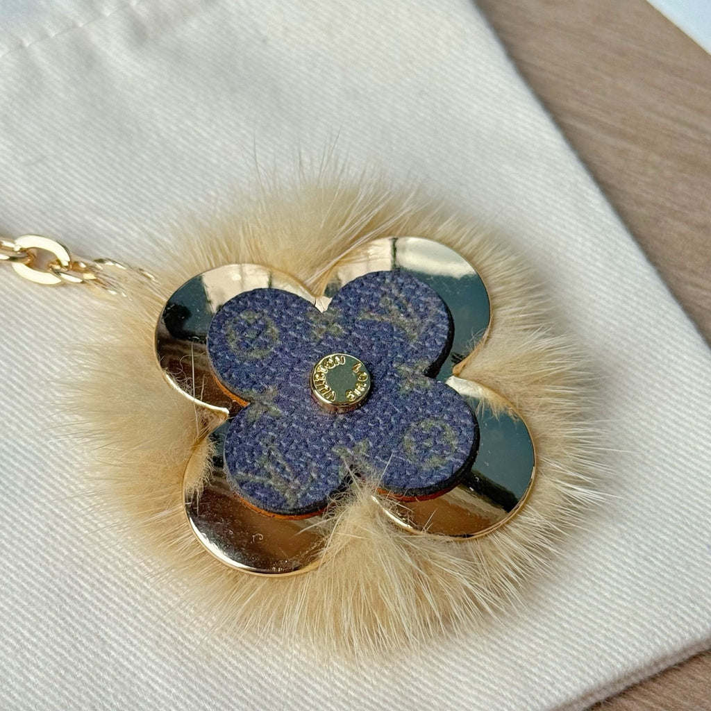 Louis Vuitton blue flower keychain detail with faux fur trim and gold center emblem