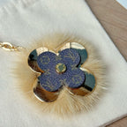 Louis Vuitton blue flower keychain detail with faux fur trim and gold center emblem