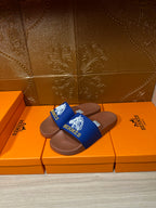 Pair of Hermes slide sandals, blue logo strap over brown footbed, on boxes