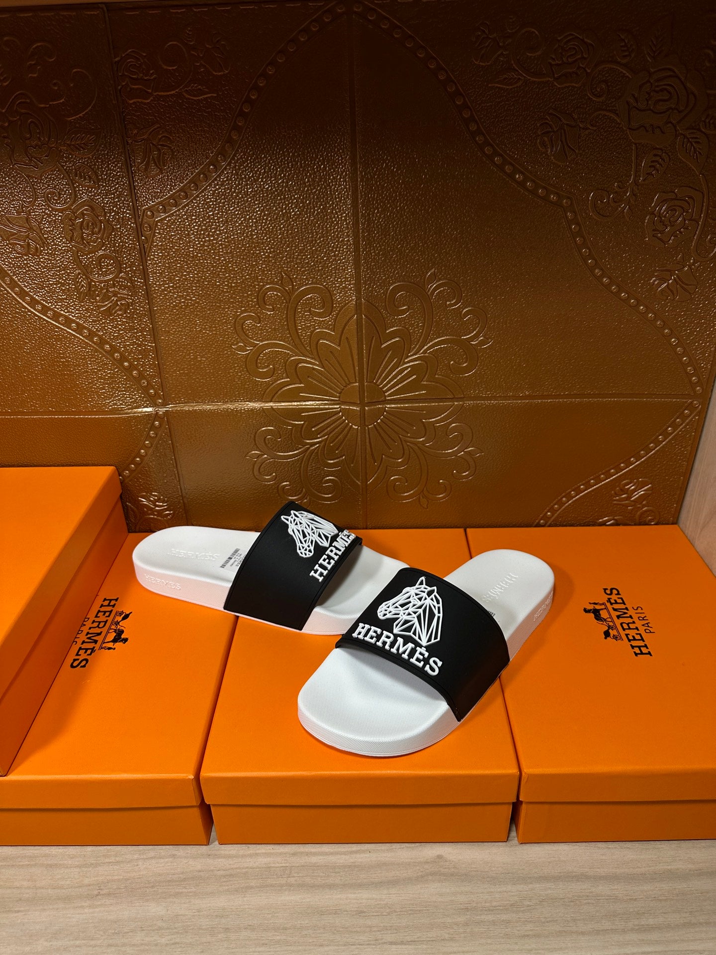 Hermes slide sandals, side view with white footbed and black strap with Hermes emblem