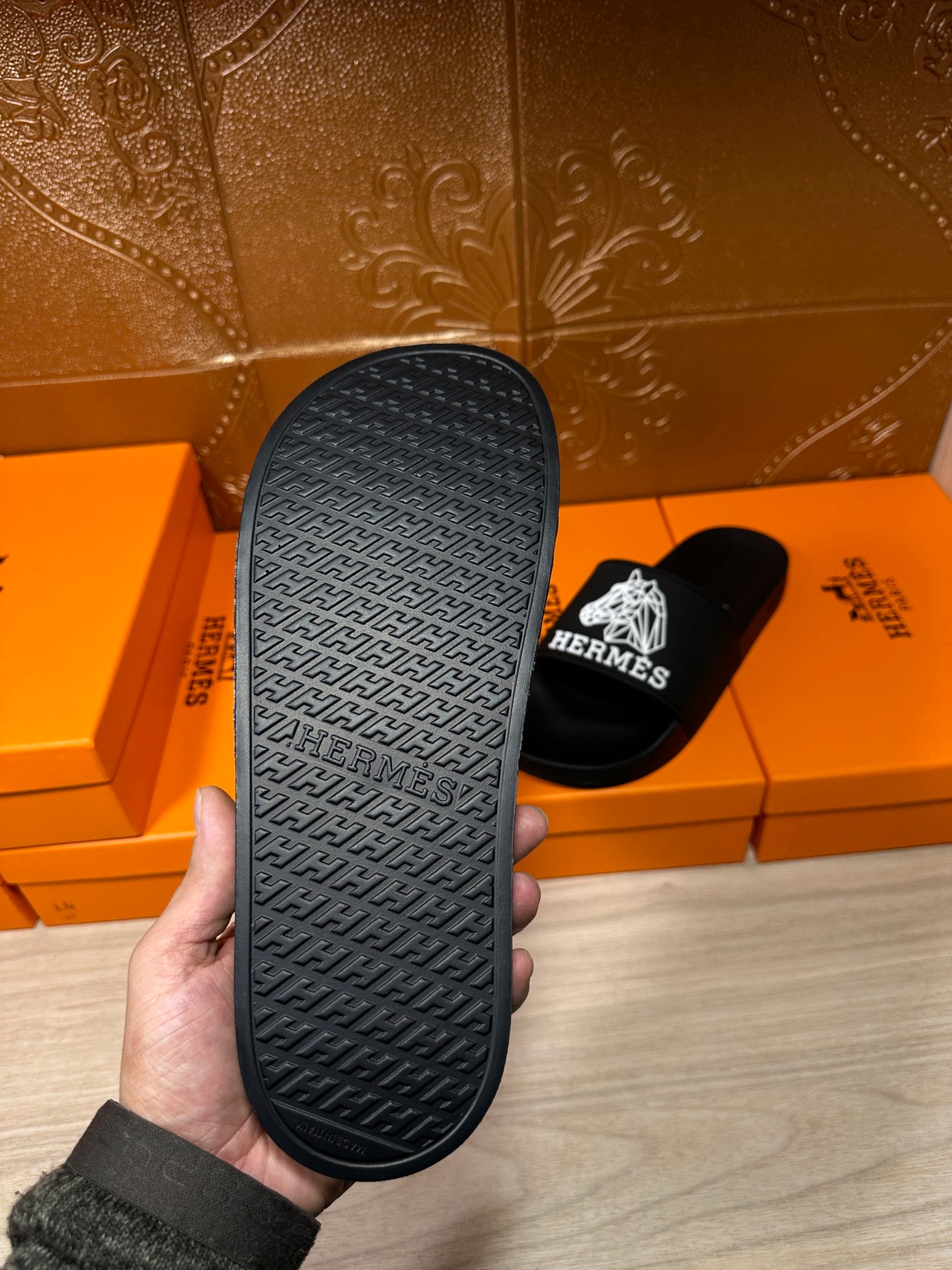 Hermes black slide sandal outsole with textured pattern and Hermes logo markings