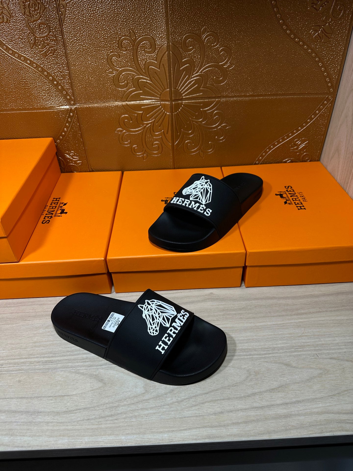 Hermes black slide sandals with white Hermes logo graphic on wide strap