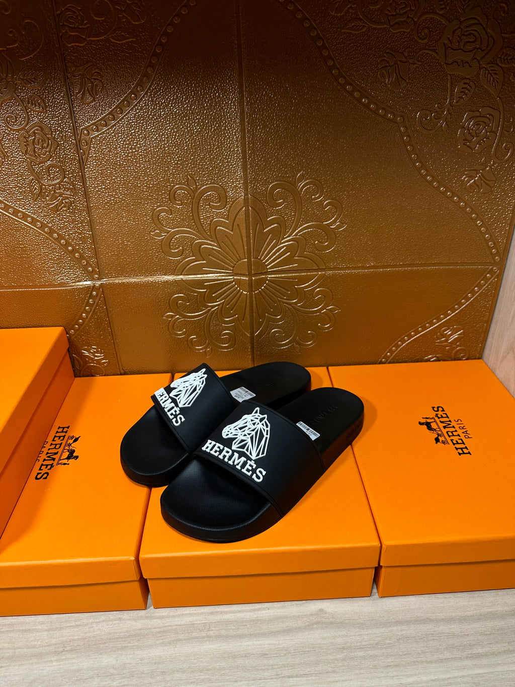 Hermes black slide sandals with white Hermes logo on the wide strap