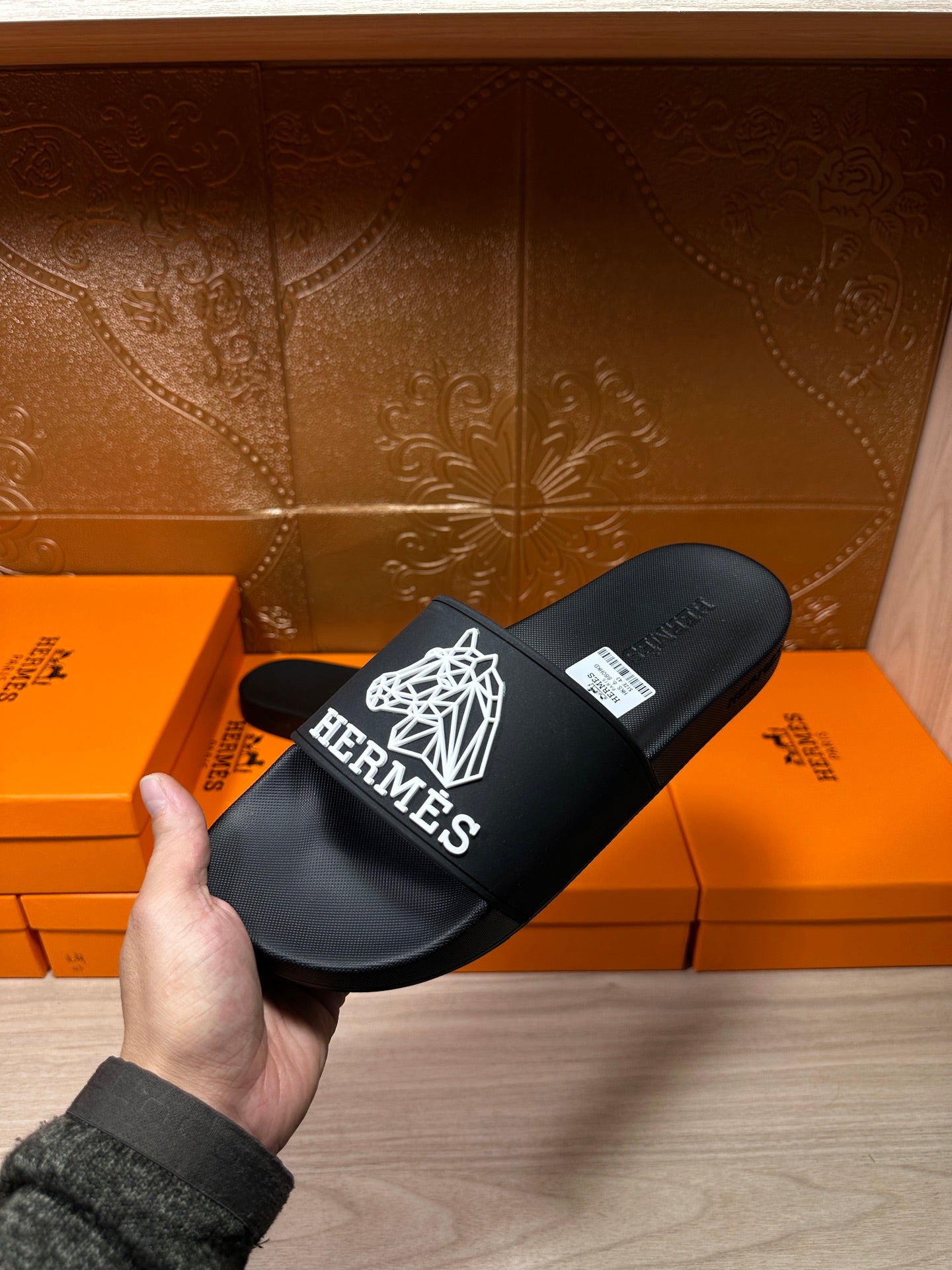 Hermes black slide sandal with white geometric logo and Hermes branding on strap