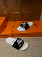 Hermes slide sandals, black strap with white emblems on white contoured footbed