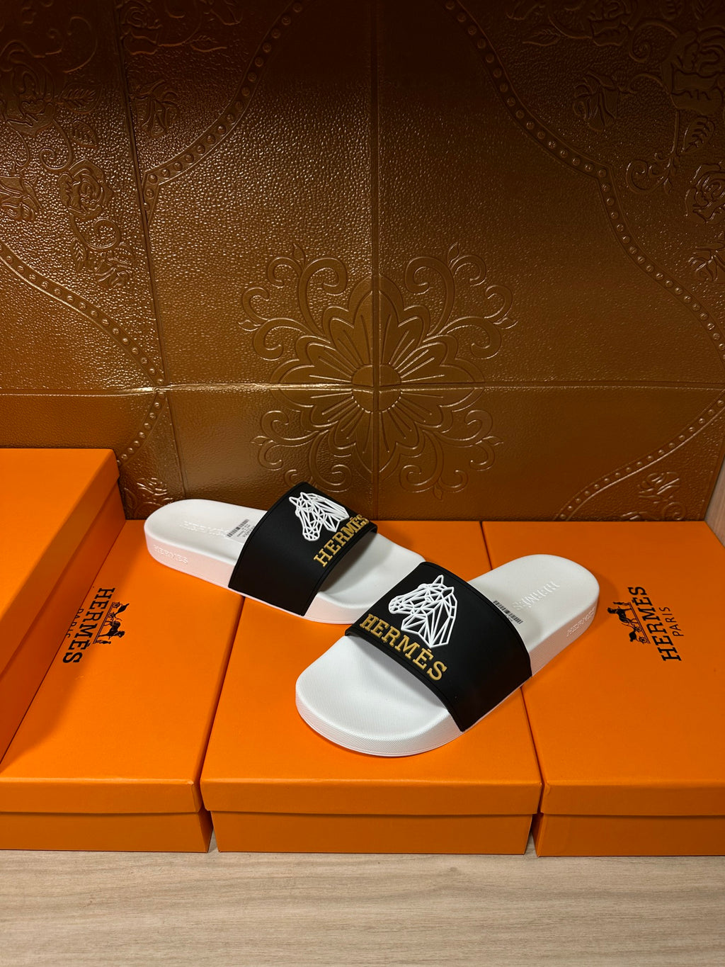 Hermes slide sandals with black logo strap and white footbed, pair view