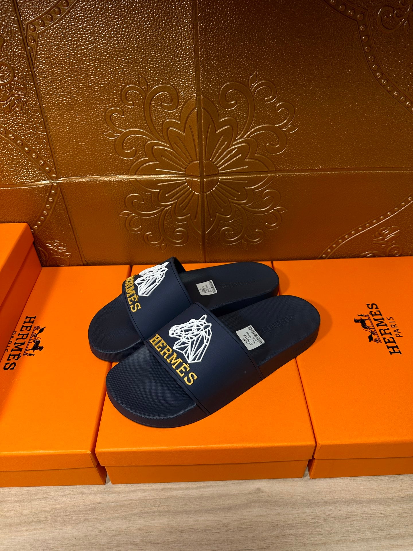 Navy slide sandals with white HERMES logo lettering and strap detail