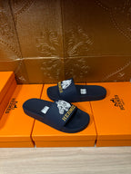 Navy slide sandals with white HERMES logo and wide single strap